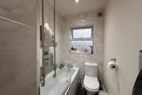 Modern tiled bathroom with a bathtub and glass ...