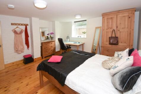 Bright, well-appointed bedroom with wooden floo...