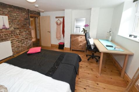 Bright, stylish bedroom with exposed brick feat...