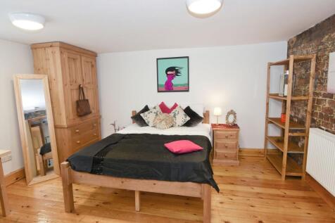 Bright, stylish bedroom with warm wooden floors...