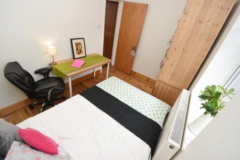 Bright, neatly furnished bedroom with a comfort...