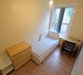 Bright, simply furnished single bedroom with a ...