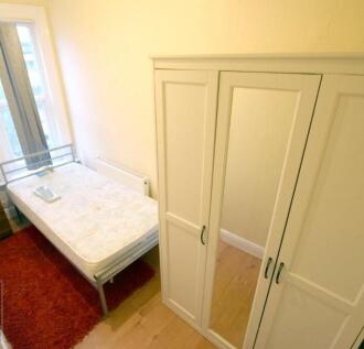 Bright furnished bedroom with a single metal be...