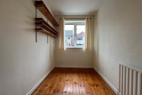 Bright, simple single bedroom with original woo...