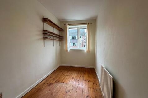Narrow, well-kept single bedroom with wooden fl...
