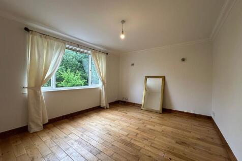 Bright, empty bedroom with large window framing...