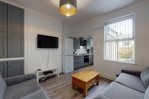 Bright, modern living room with matching grey s...