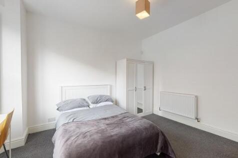 Bright, simply styled double bedroom with a com...