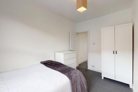 Bright, simply furnished bedroom with a comfort...