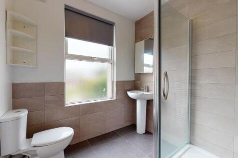 Bright, modern bathroom with large frosted wind...