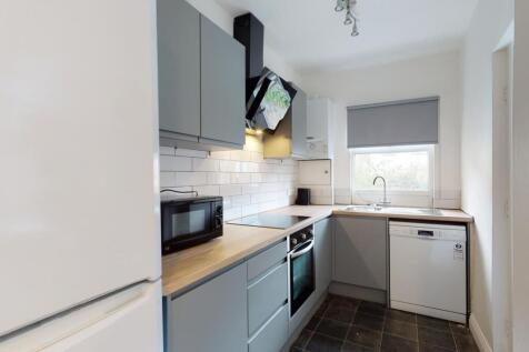 Modern galley kitchen with grey cabinets, integ...