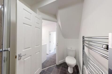 Bright, modern bathroom with white fixtures, ch...