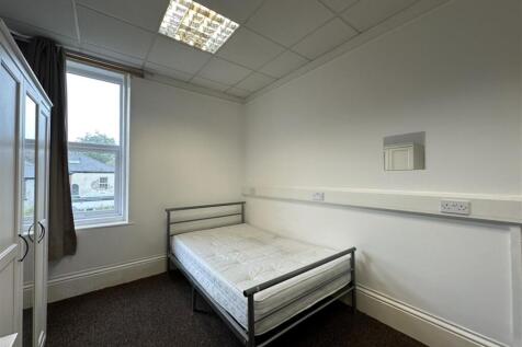 Bright, simply furnished bedroom with a double ...