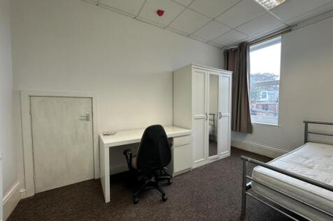 Bright, simply furnished bedroom with large win...