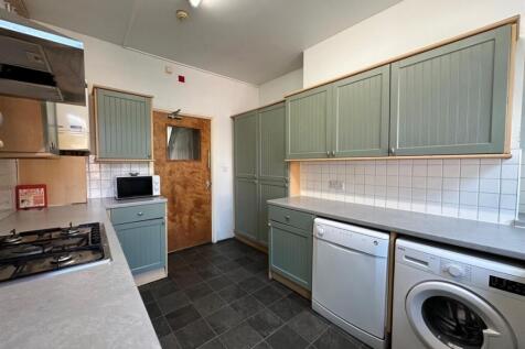 Bright galley-style kitchen with modern sage-gr...