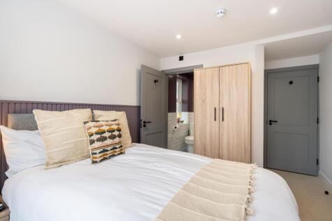 A bright, inviting double bedroom featuring neu...