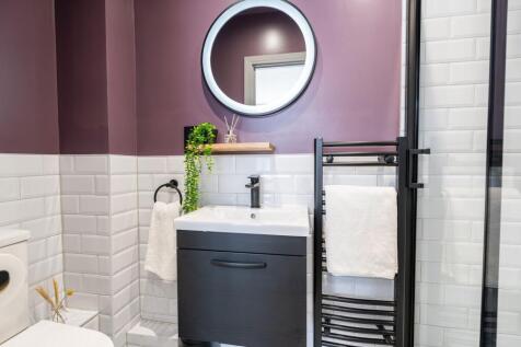 Modern bathroom featuring a sleek black vanity ...