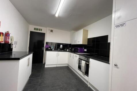 Bright, modern communal kitchen with sleek blac...