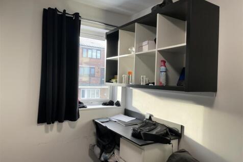 Compact bedroom with a window providing natural...