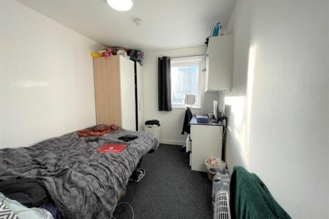 Compact furnished bedroom with a comfortable si...