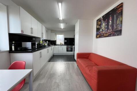 Bright modern kitchen with long run of white ca...