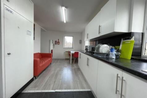 Bright modern kitchen with white cabinetry, dar...