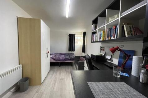 Bright, neatly organised single bedroom with a ...