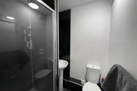 Compact modern bathroom with a corner shower cu...