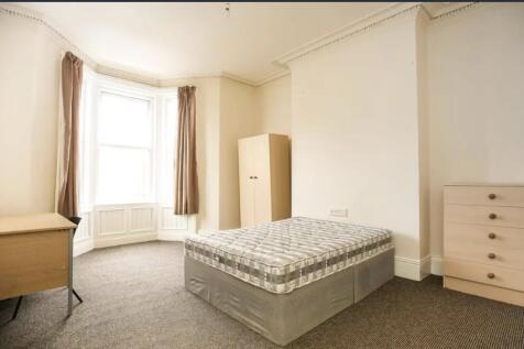 Bright, airy bedroom with a large bay window, n...