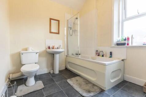 Bright bathroom with a bath and shower screen, ...