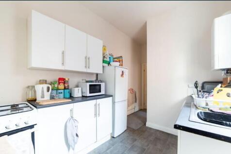 Bright, tidy kitchen with white cabinetry, free...