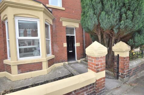 Red-brick terraced house with bay window, black...