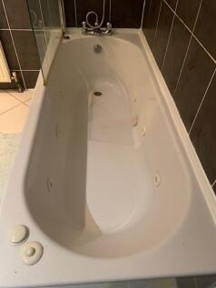 A clean and spacious bathroom with a large bath...