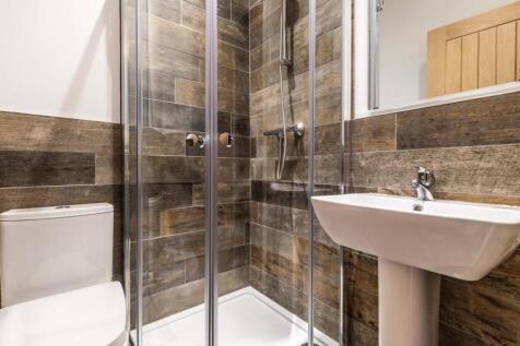 Stylish bathroom with a modern glass-enclosed s...