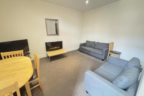 A spacious, well-maintained living room featuri...