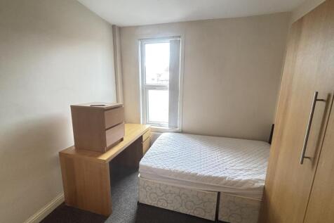 A bright, tidy bedroom featuring a comfortable ...