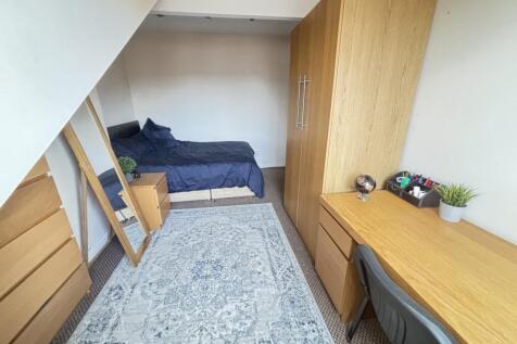 A neat and cozy single bedroom featuring a bed,...