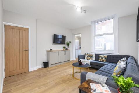 A bright, spacious living room with large windo...