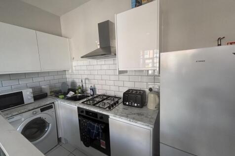 A modern kitchen with white cabinets, a stove, ...