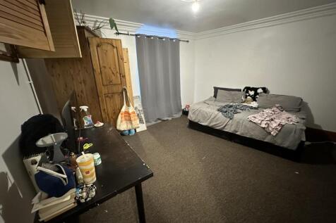 Neat, simply furnished double bedroom with a do...