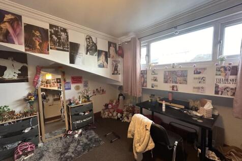 A cozy bedroom featuring a desk and chair, deco...