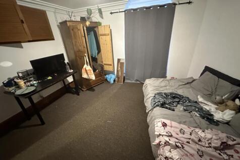 A modest bedroom featuring a double bed with so...