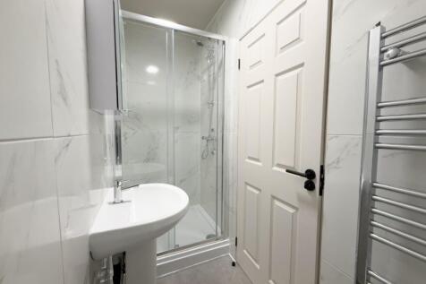 Bright, modern bathroom with a glass shower enc...