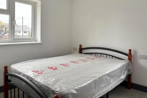 Bright, simply furnished bedroom with a metal-f...