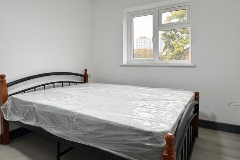 Bright, simply furnished bedroom with a metal d...