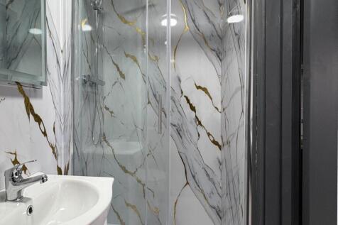 Modern bathroom with a glass-enclosed shower, s...