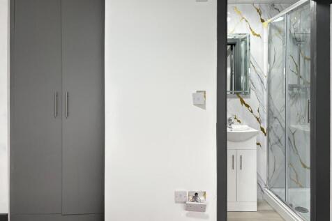 Bright, modern bathroom with a glass shower enc...