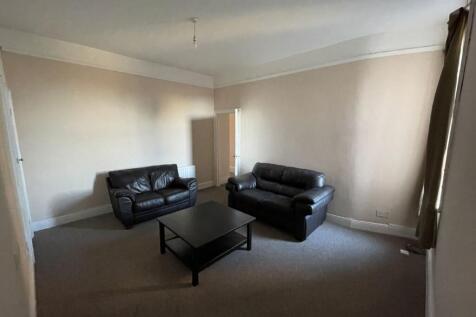 Spacious living room with two leather sofas, ce...