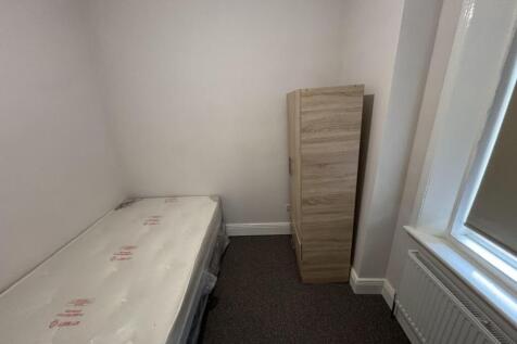 A tidy single bedroom featuring a fitted wardro...