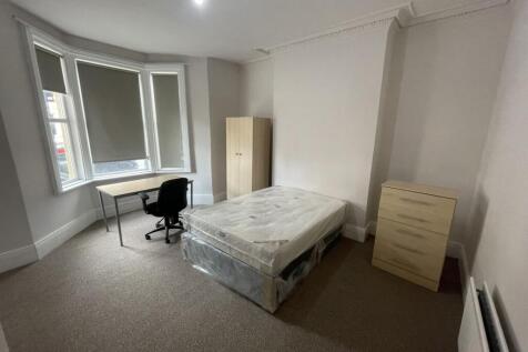 Bright, spacious bedroom with a large bay windo...